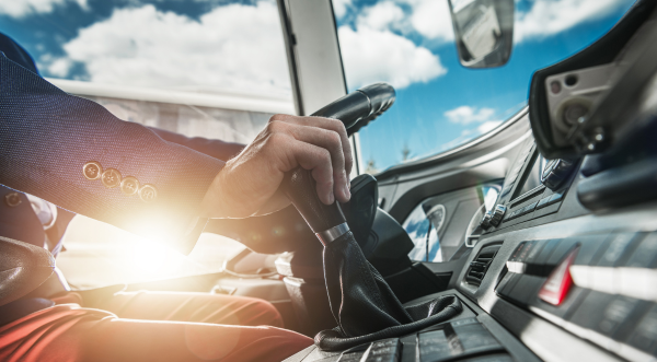 Conducteur de bus tenant son levier de vitesse et son volant. 